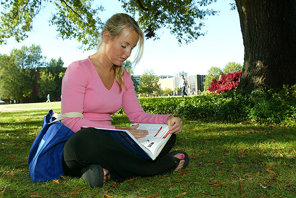 Girl studying in grass near Library