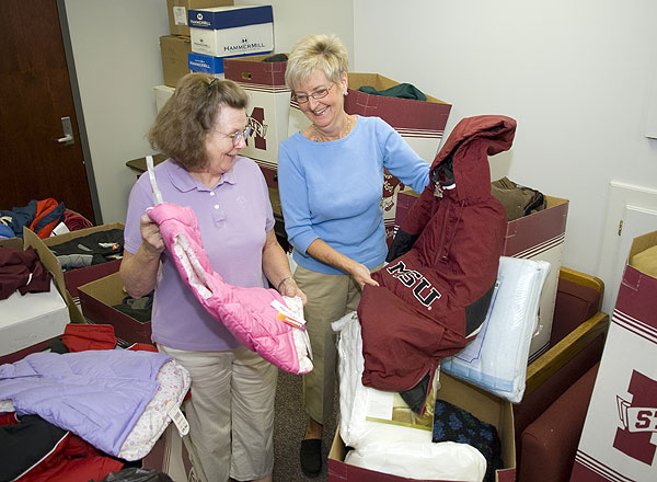 Pat Lee and Linda Jo Templeton sort through coats for coast