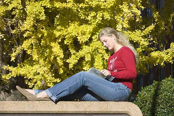 Robyn reading book with Gingko tree in background