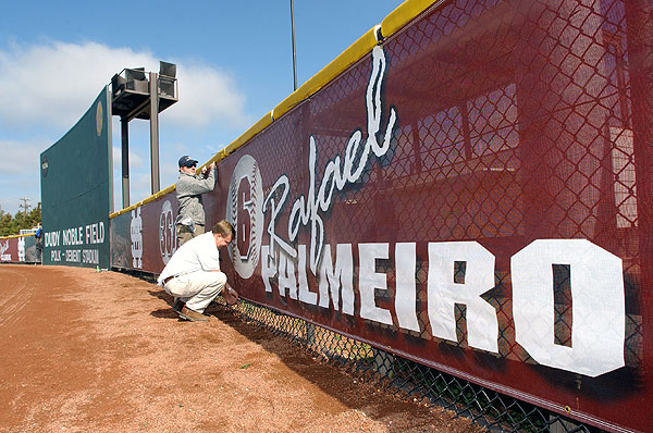 Putting up netting on outfield baseball fence