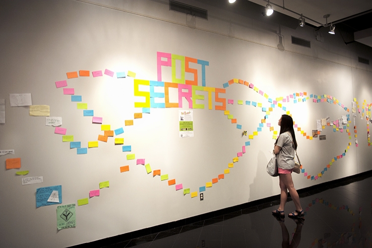 Heather Hart is looking at the Post Secret in the Union Gallery