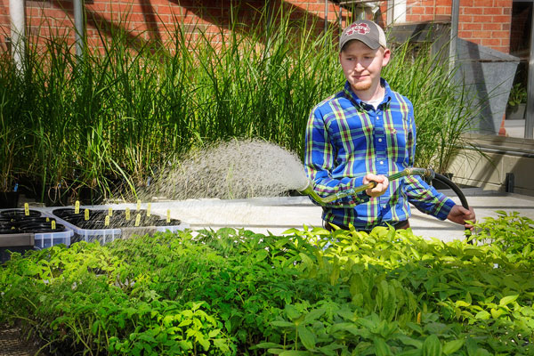 Student Watering Plants At West Point Farm