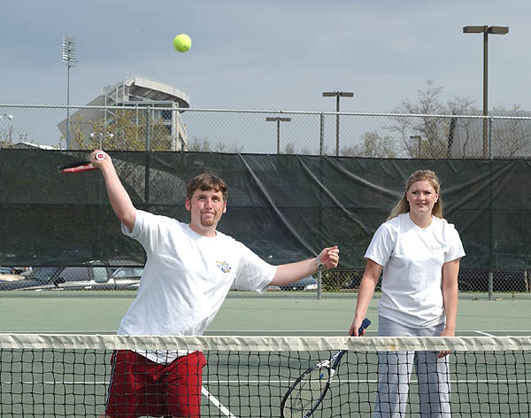 Students volley during tennis class