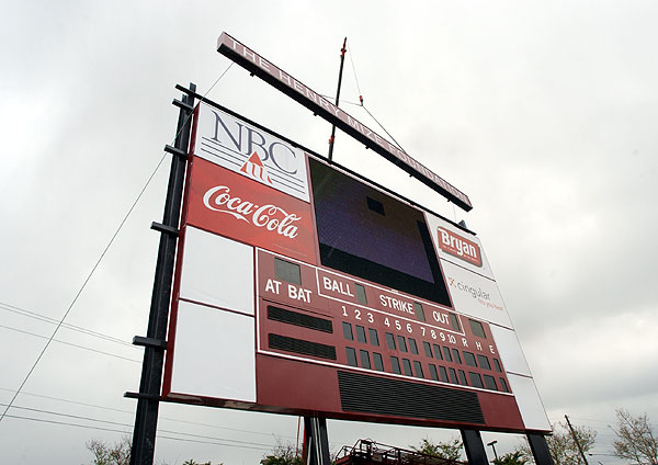 Putting up new scoreboard at baseball field