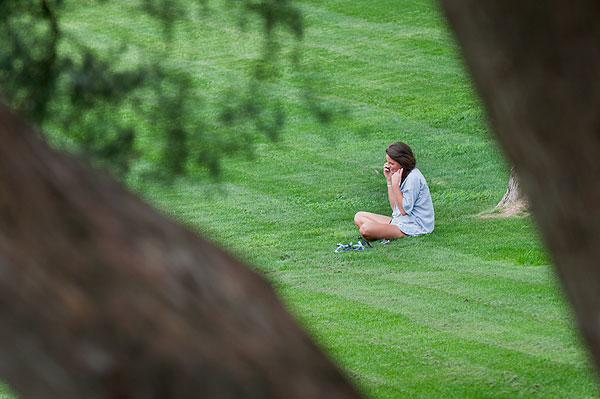 Student relaxing on phone in rye grass