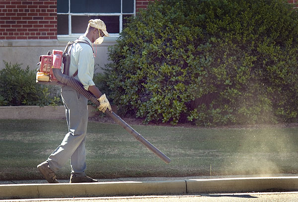 Campus Landscape uses blower to clean sidewalks