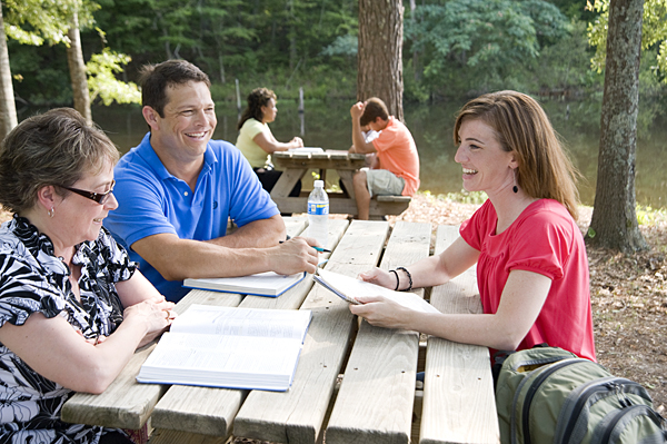 Meridian students enjoy the weather by their campus lake