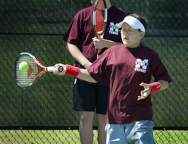 Tennis camper hits a forehand