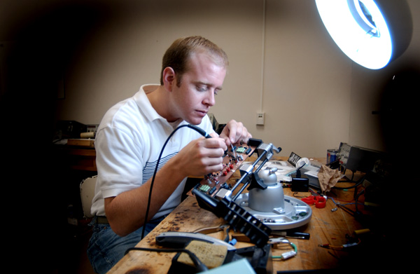 Jim Gafford checks circuit board in electrical engineering