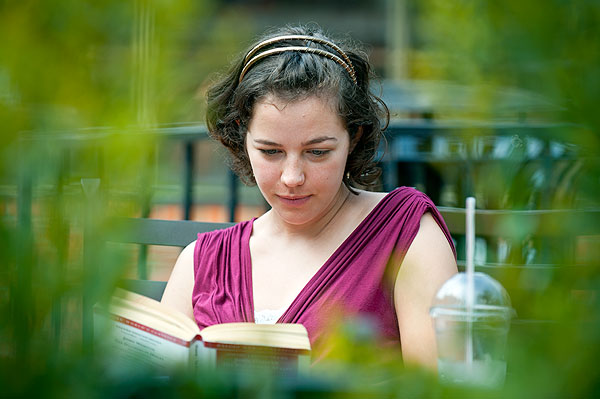 Student reading book near bakery