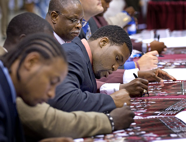 Football players sign autographs at the Miss. Extravaganza