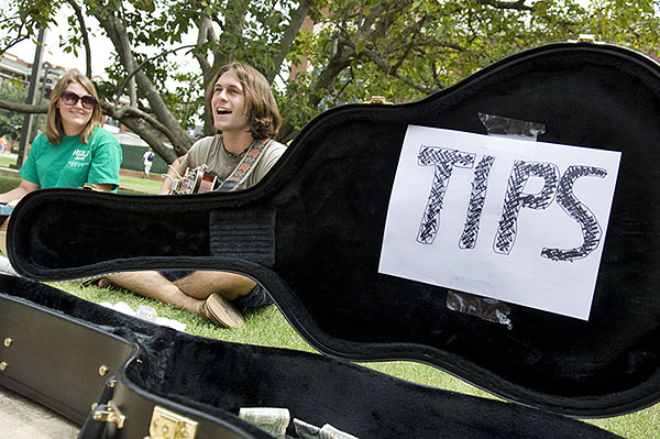 Student busking with guitar