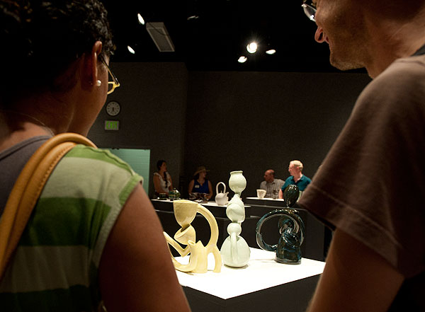 Students admiring ceramics at the Invitational Cup Exhibit