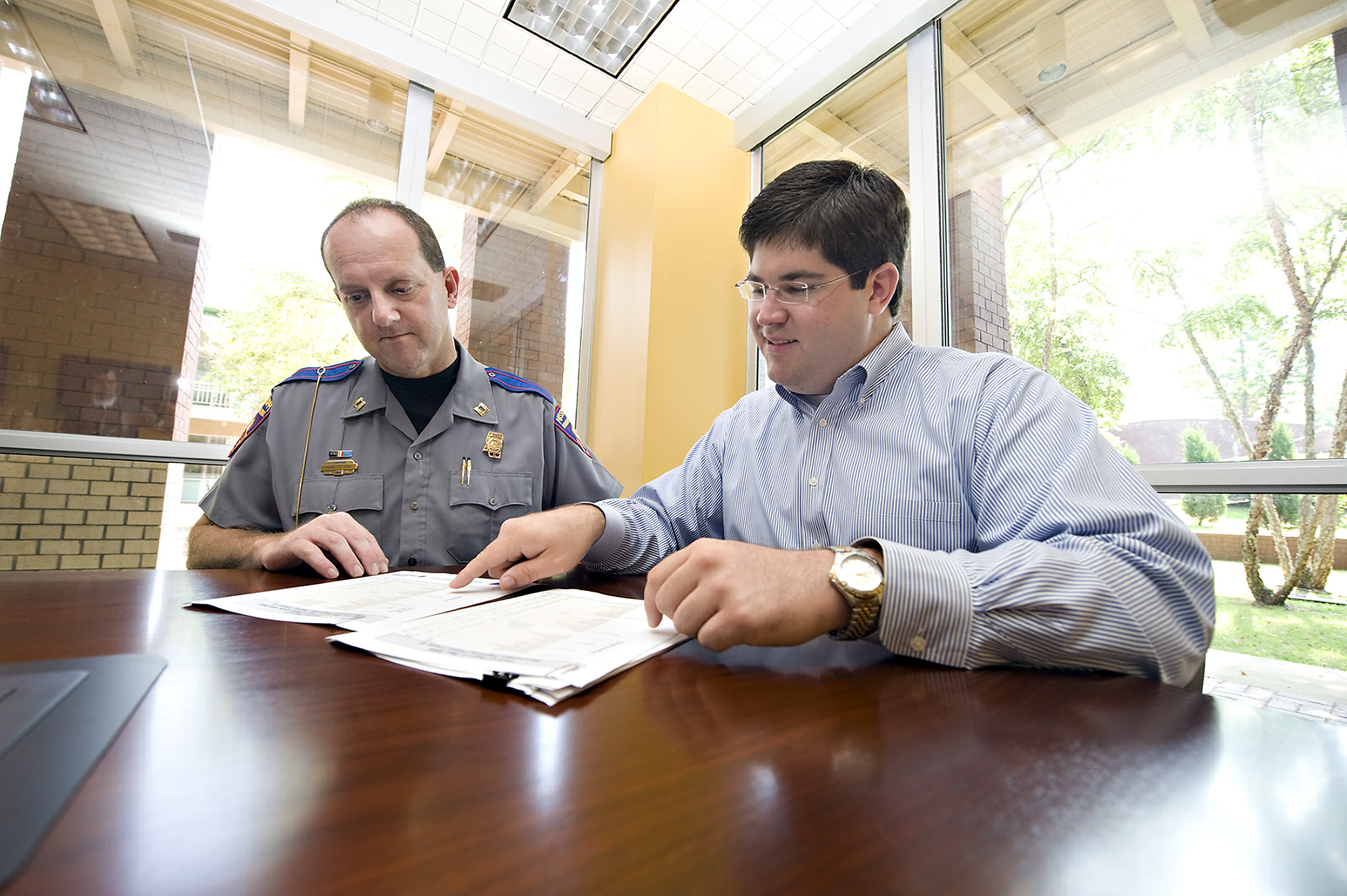 Capt. Randy Ginn, left, of the Mississippi Highway Patrol in Starkville and research associate at Mississippi State University's Social Science Research Center Lee Weiskopf review reports produced by the research center based on data from the state agency. As of July, all highway patrol districts in the state use the upgraded reporting system.