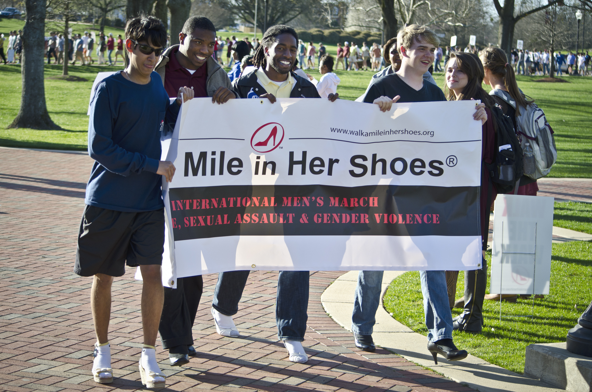 "Walk a Mile in Her Shoes" participants carry a banner during last year's event. On Tuesday, more than 500 are expected to turn out to support awareness of relationship violence and sexual assault.