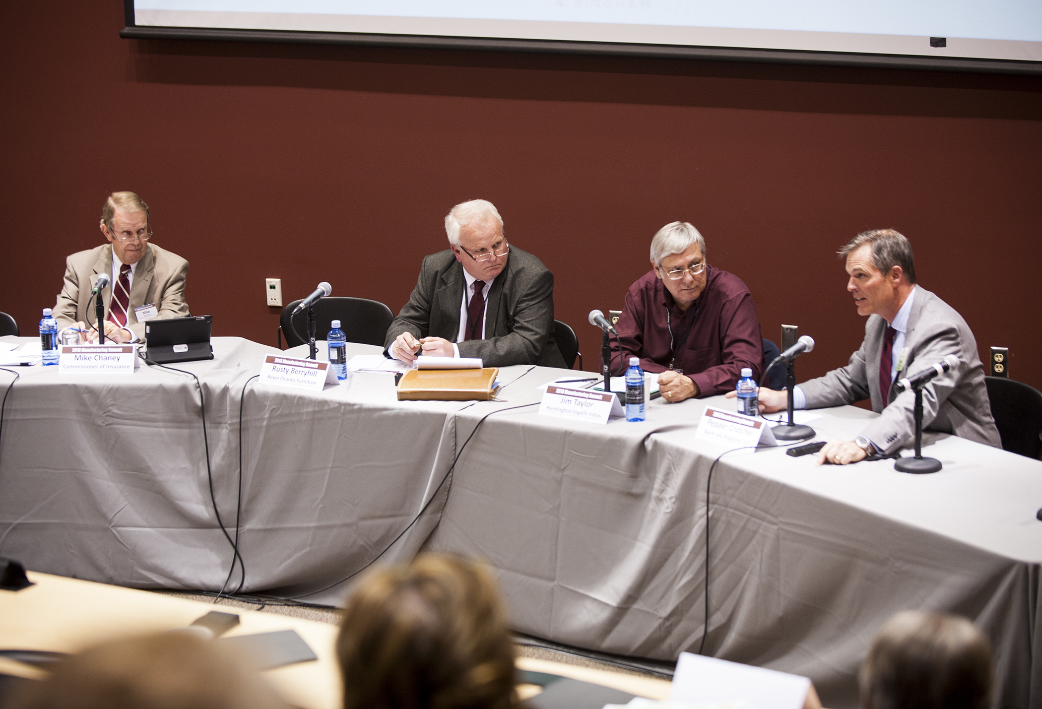 Panelists Mike Chaney, from left, Rusty Berryhill, and Jim Taylor, look on as Pepper Crutcher discusses implications of the Affordable Care Act for manufacturers and other state businesses.</p><br />
<p>