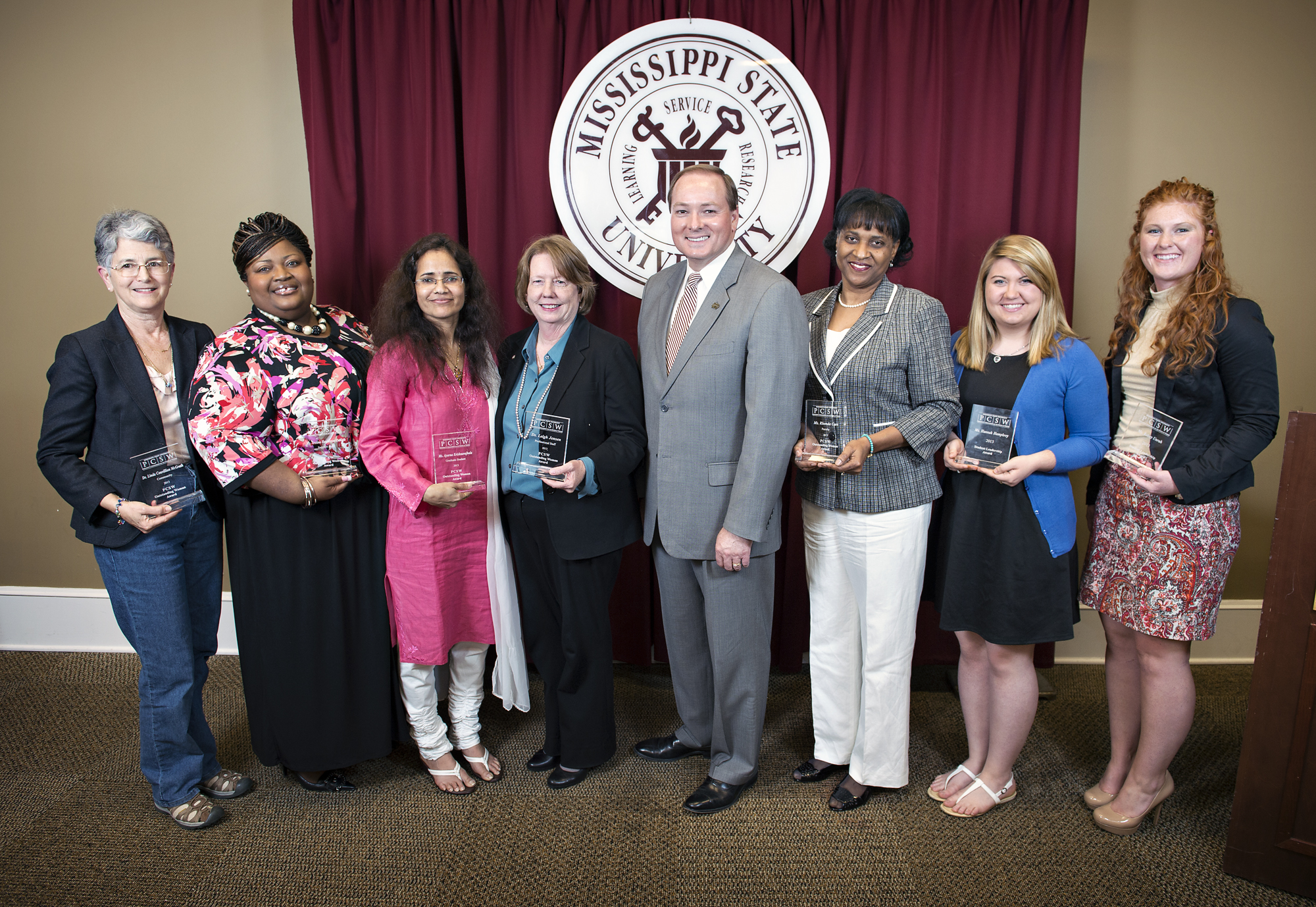 Mississippi State University President Mark E. Keenum, center, presented the 2013 Outstanding Women Award winners. From left are Linda Couvillion McGrath, Aretina Hankerson-Daniels, Aparna Krishnavajhala, Leigh Jensen-Crawford, Keenum, Rhonda Carr, Hannah Humphrey and Kelsey Unruh.