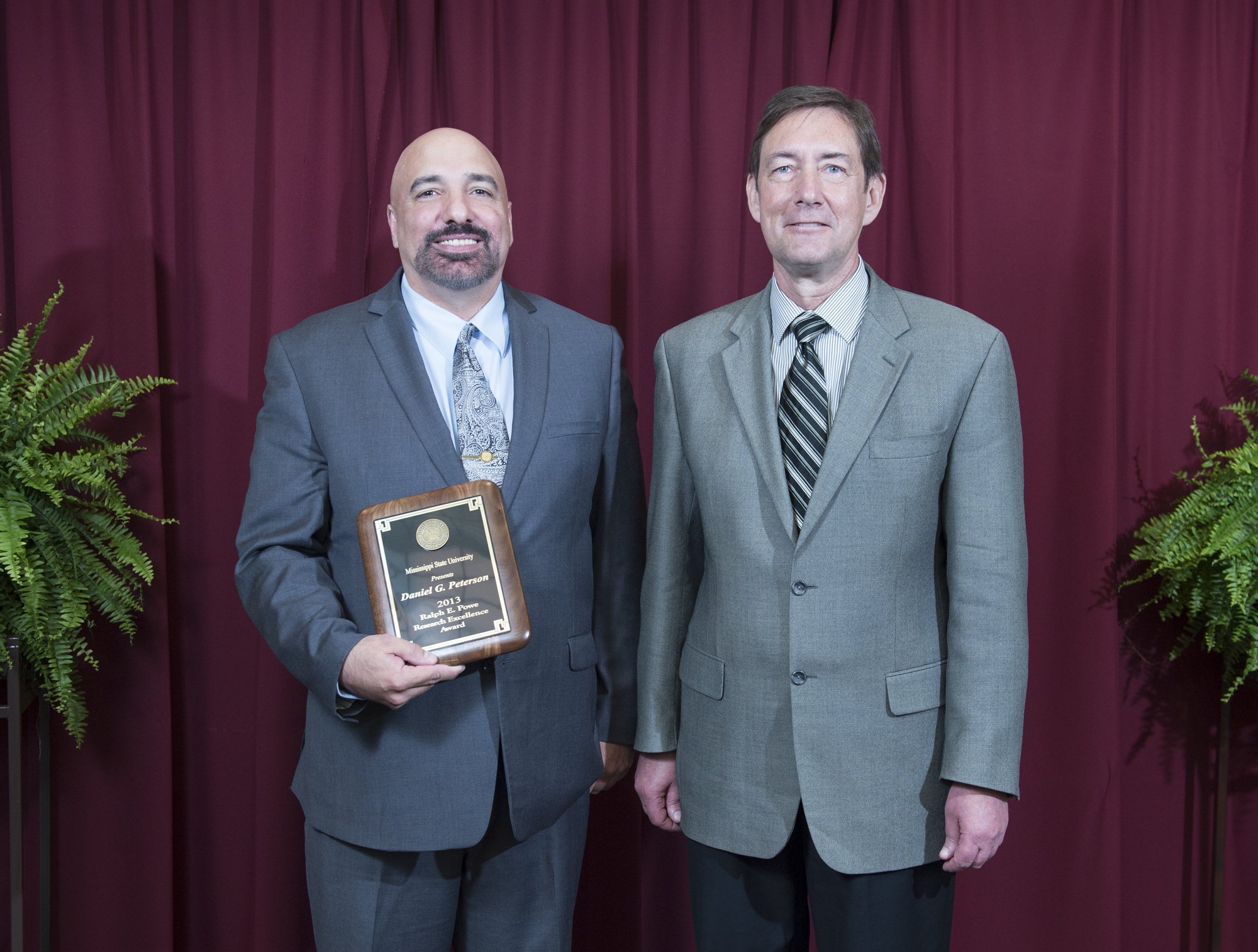 Plant and soil sciences department professor Daniel G. Peterson, left, the winner of the 2013 Ralph E. Powe Research Excellence Award, was congratulated by Greg Bohach, vice president for agriculture, forestry and veterinary medicine. 