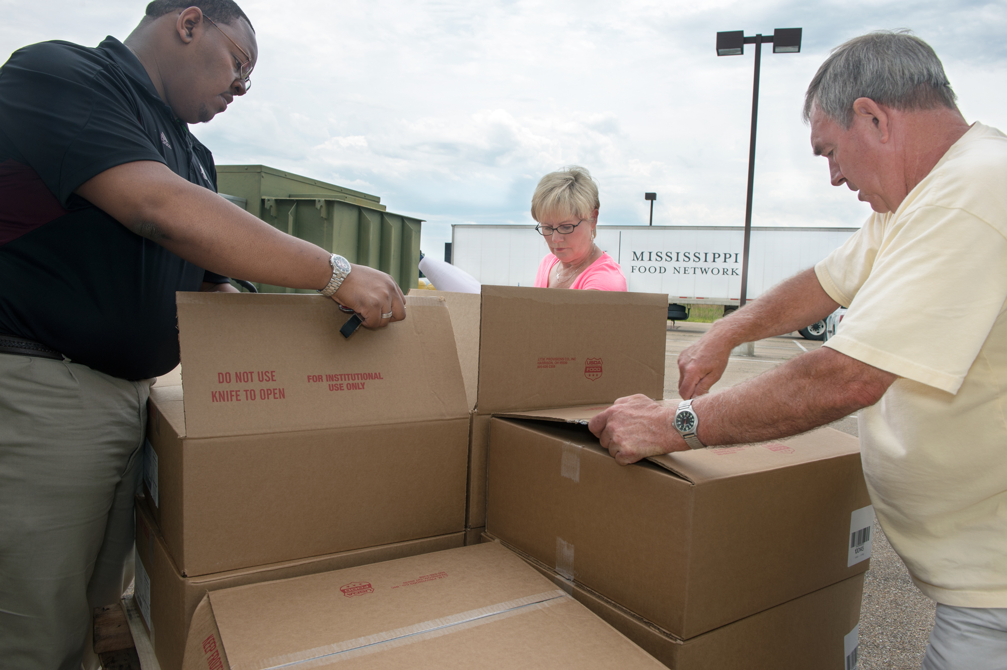 MSU graduate student Stedmond Ware of Greenwood, left, and Johnnie Armstrong and Buddy Downer, both of Starkville's Pinelake Church, unload food from a shipment that has been delivered from the Mississippi Food Network. The items help stock the shelves at the church's food pantry and help feed those in need in the local community, including MSU students who qualify to participate.