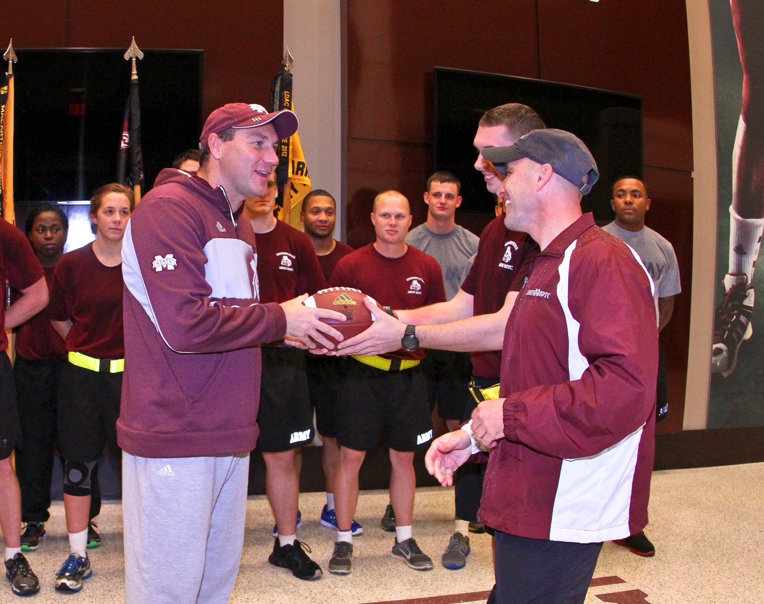 MSU Head Football Coach Dan Mullen receives the game ball from Bulldog Army ROTC cadets at the conclusion of Egg Bowl Run Monday. 