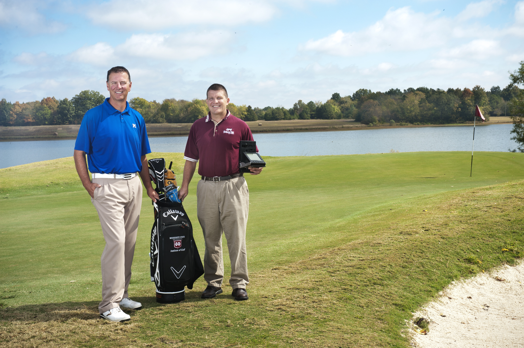 Tony Luczak with MSU's Institute of Golf, left, and Tom Lacy, aerospace engineering interim department head, stop for a photo on the course.