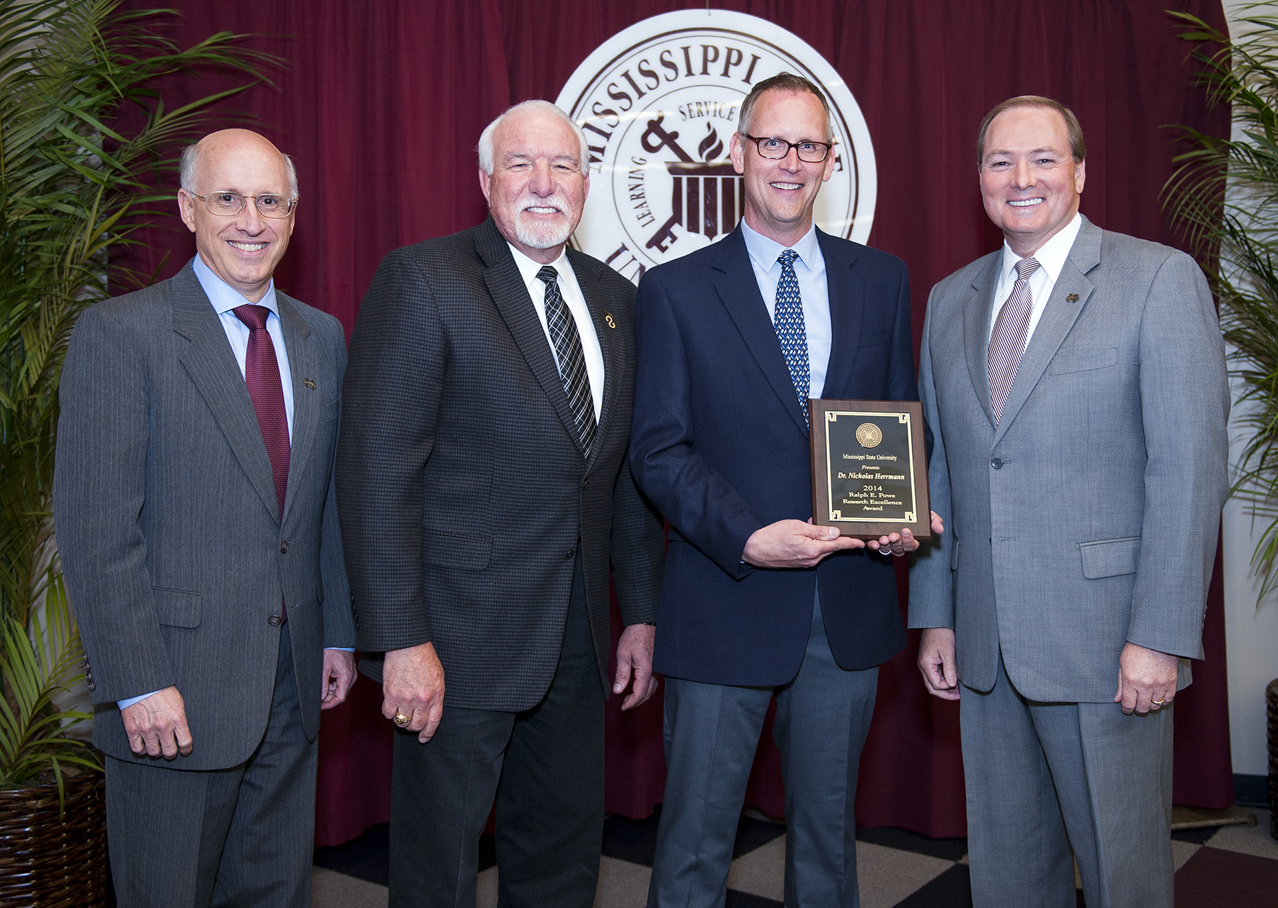 Mississippi State University honored associate professor of anthropology Nicholas Herrmann (holding plaque) with the 2014 Ralph E. Powe Research Excellence Award on Wednesday [April 30]. MSU Vice President for Research and Economic Development David Shaw (l-r), Associate Vice President for Agriculture, Forestry and Veterinary Medicine Bill Herndon and President Mark E. Keenum congratulated Herrmann on his achievement during a luncheon at the Hunter Henry Center. </p><br />
<p>