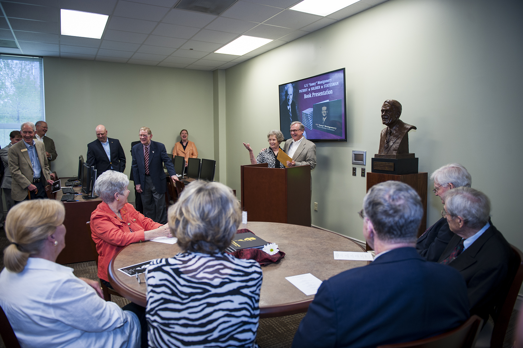 Mississippi State Libraries officials gathered with Montgomery Foundation representatives at MSU-Meridian on Friday to celebrate the release of the "G.V. 'Sonny' Montgomery: Patriot, Soldier, Statesman" pictorial book. At the podium, MSU Dean of Libraries Frances Coleman and Montgomery Foundation President Emeritus Bob Bailey unveil the book.