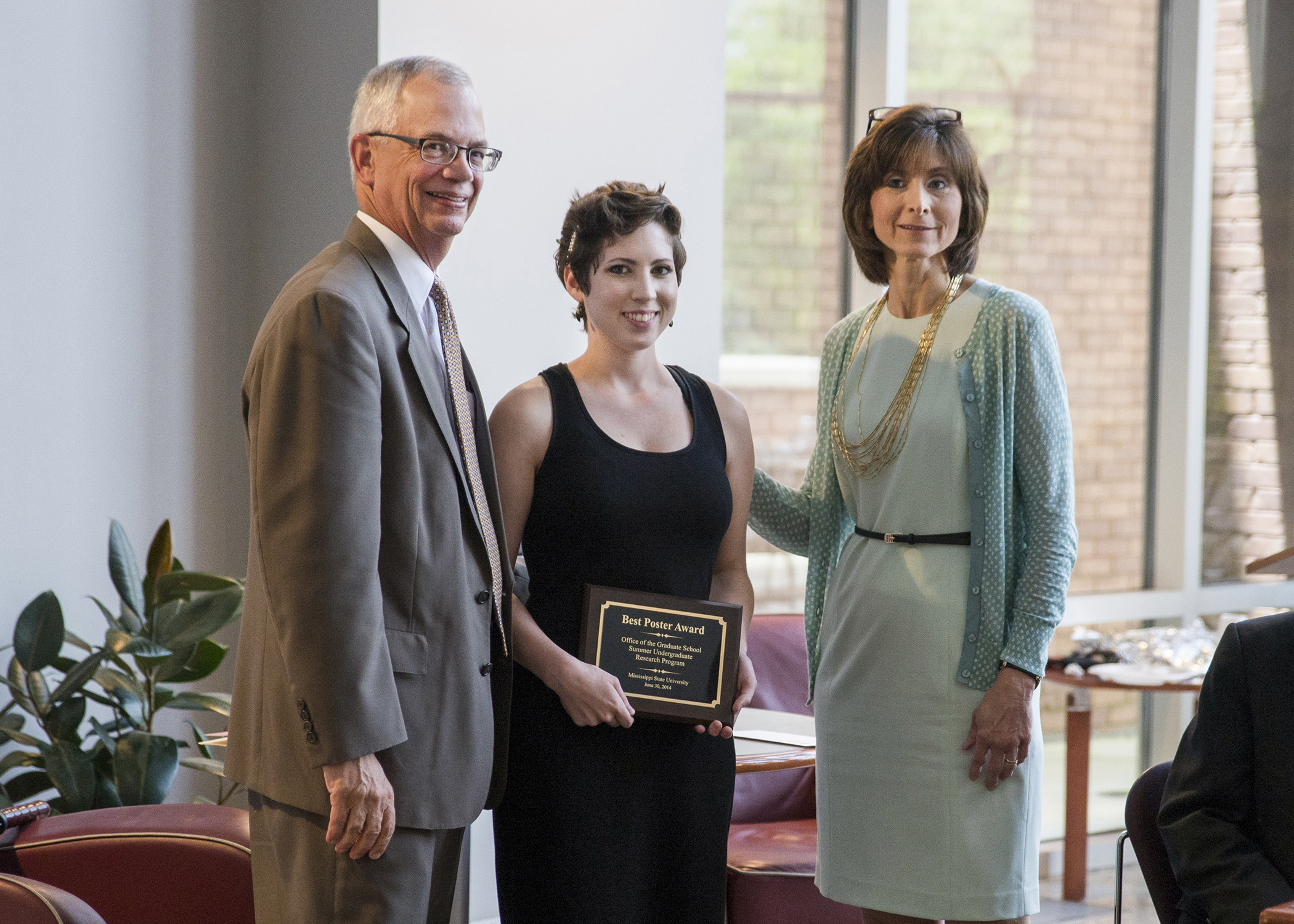 MSU senior Jacqueline B. Dorman, center, was honored this week for the best presentation at Mississippi State's 2014 Undergraduate Summer Research Symposium. Extending congratulations are Jerry Gilbert, provost and executive vice president, and Karen S. Coats, associate graduate school dean.