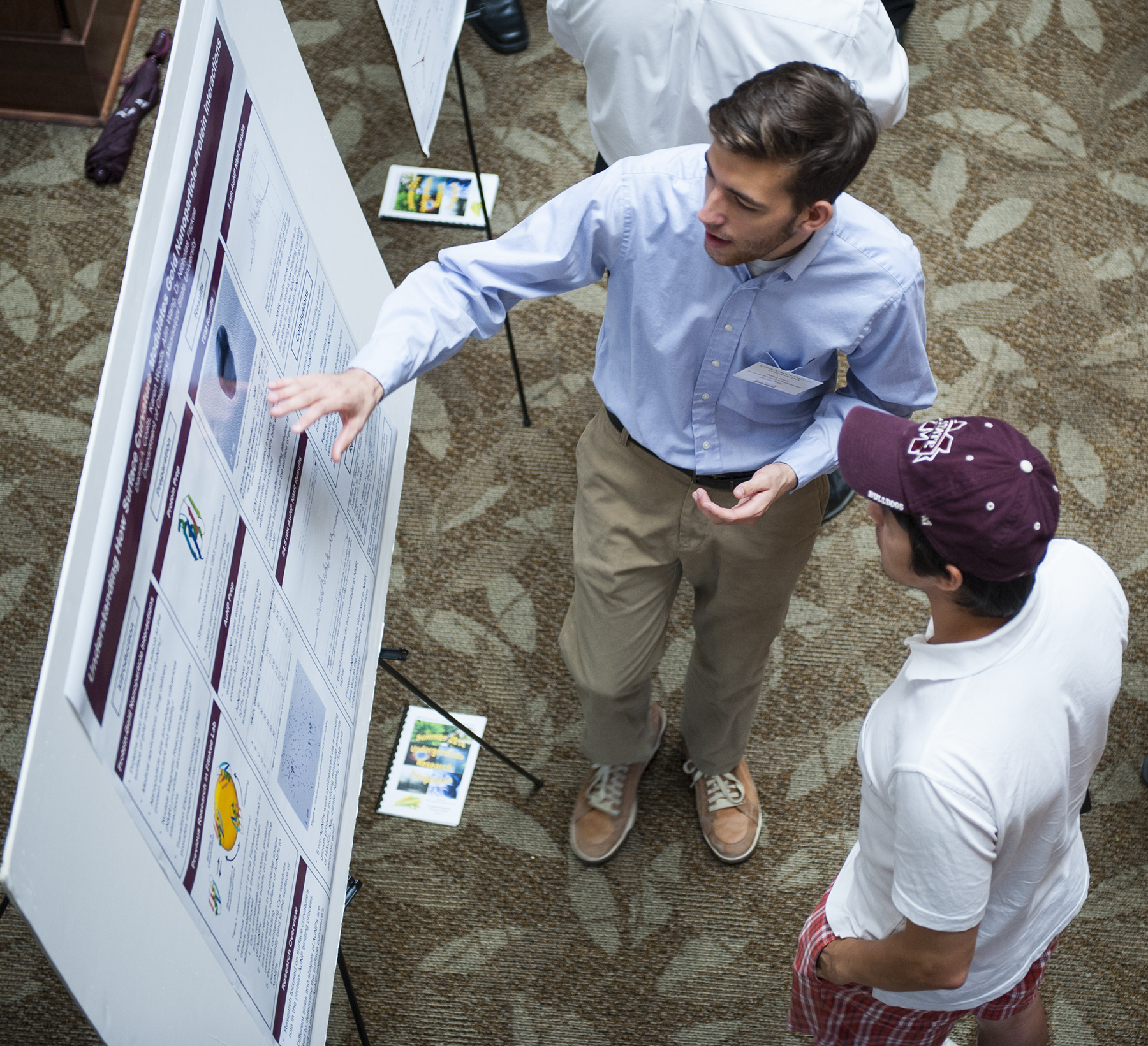 At Mississippi State's summer Undergraduate Research Symposium, sophomore chemistry major D. Alex Coats, son of William and Deborah Coats of College Station, Texas, explains his research to mechanical engineering doctoral student Pratik Parajuli.