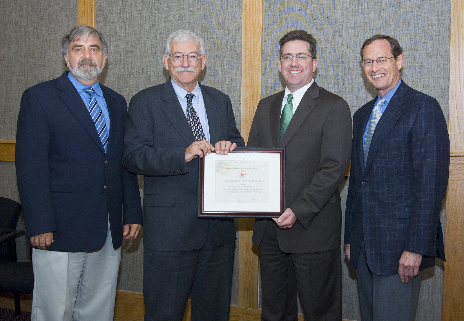 Navy Technology Center official Frederick Williams (second from left) presents the certificate to MSU vice president Kirk Schulz as CAVS officials Tomasz Haupt (left) and Rand German look on.