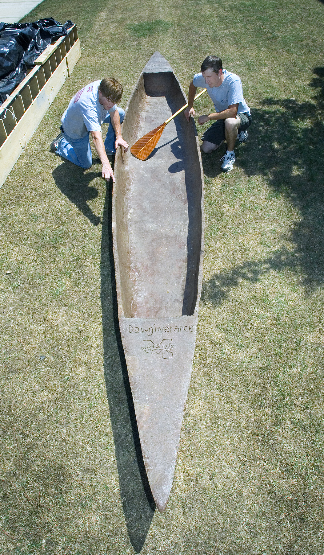 Austin Moore of Jackson (l) and Jesse Doyle of Picayune inspect MSU's 330-pound concrete racing canoe.