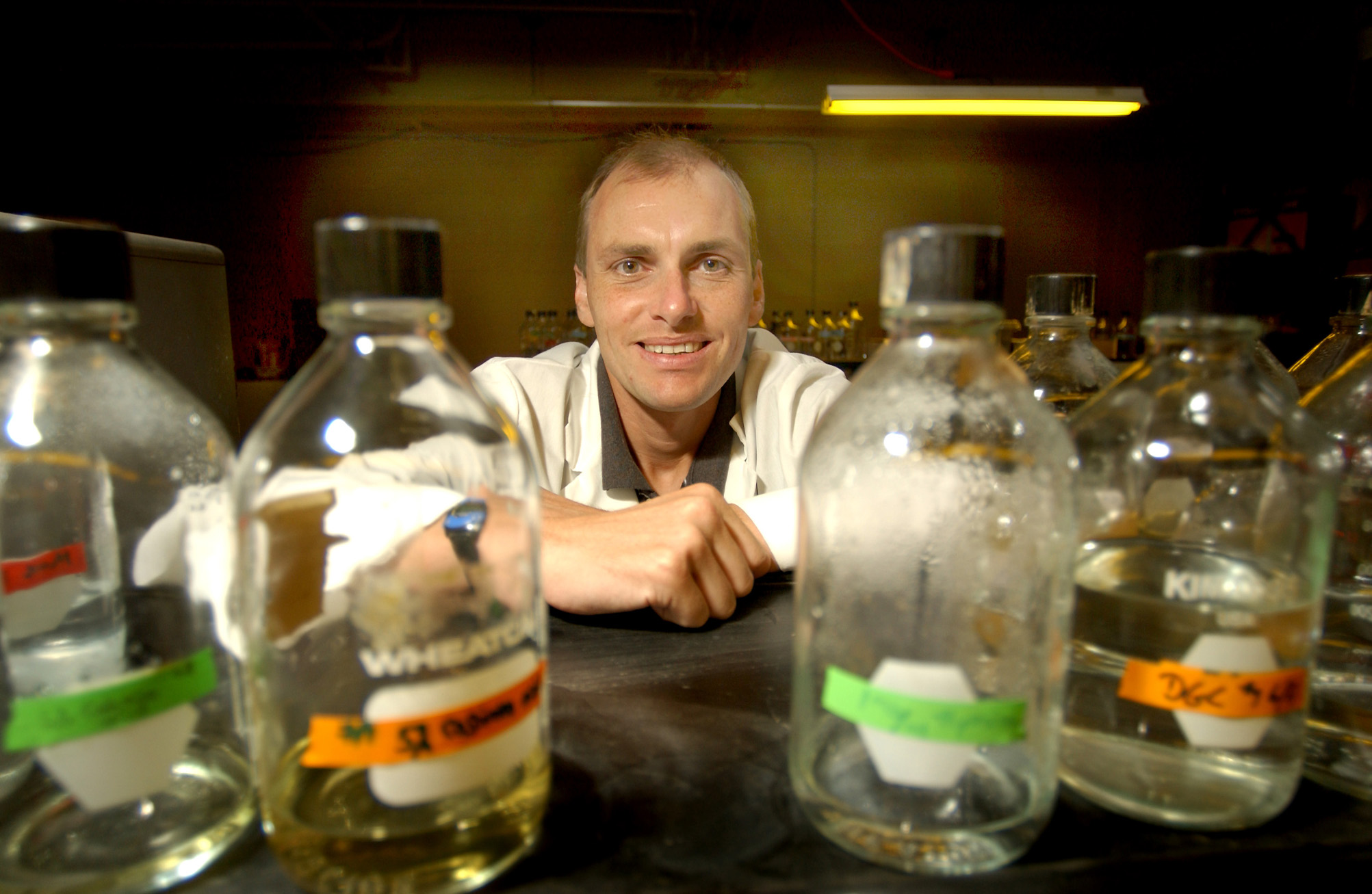 <br /><br />
Mississippi State University biologist Justin Courcelle hopes his scientific study of how damaged human cells repair themselves may one day lead to improved treatments in the fight against cancer and aging.  At work in his MSU laboratory, he utilizes yellow lights to control the repair of E. coli bacteria cells damaged by ultraviolet light.  The bottles contain media used to grow the bacteria. 