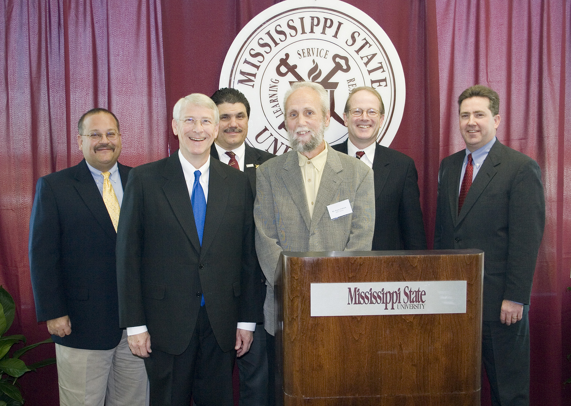 Announcing plans for location of a Mississippi State aerospace engineering center at the Golden Triangle Regional Airport Tuesday were (front, l-r) U.S. Rep. Roger Wicker, R-Miss., and Wayne Fishback of Simi Valley, Calif., who is donating land for the project; and (back, l-r) Joe Higgins, CEO of the Columbus-Lowndes Development Link; Tony Vizzini, head of MSU's aerospace engineering department; Colin Scanes, MSU vice president for research and economic development; and Kirk Schulz, dean of MSU's Bagley College of Engineering.