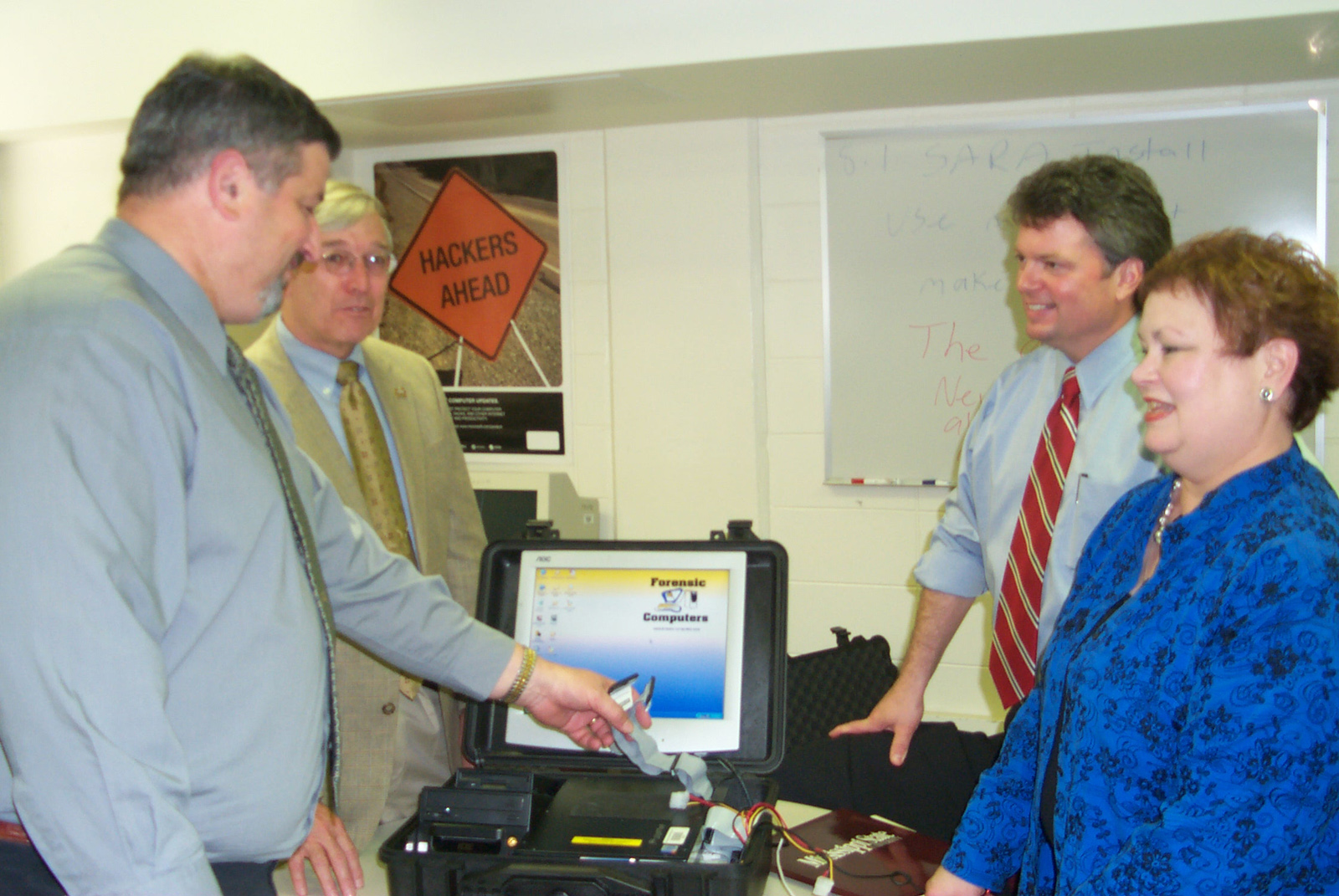 Examining a "computer forensics work center in a suitcase" at Mississippi State's Center for Computer Security recently were, l-r, MSU computer science and engineering professors Dave Dampier and Ray Vaughn, state Attorney General Jim Hood and  Jean Smith Vaughan, special assistant attorney general for cyber crime. The attorney general's office and the FBI will collaborate with MSU and Jackson State University to establish a law enforcement training center in Jackson devoted to fighting such Internet-related crimes as pornography and identity theft.