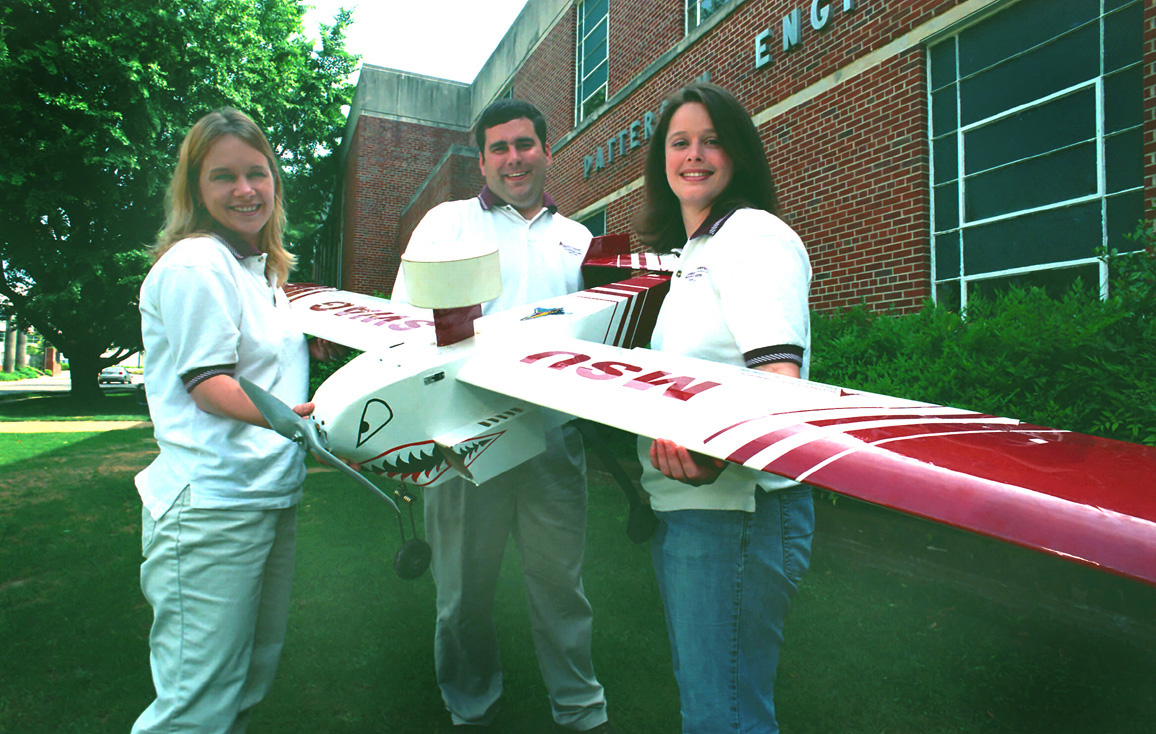 <br /><br />
Mississippi State seniors Viva Austin of Tylertown (l) and Erin Wahlers of Gulfport join faculty adviser Bryan L. Gassaway to display their radio-controlled aircraft. 