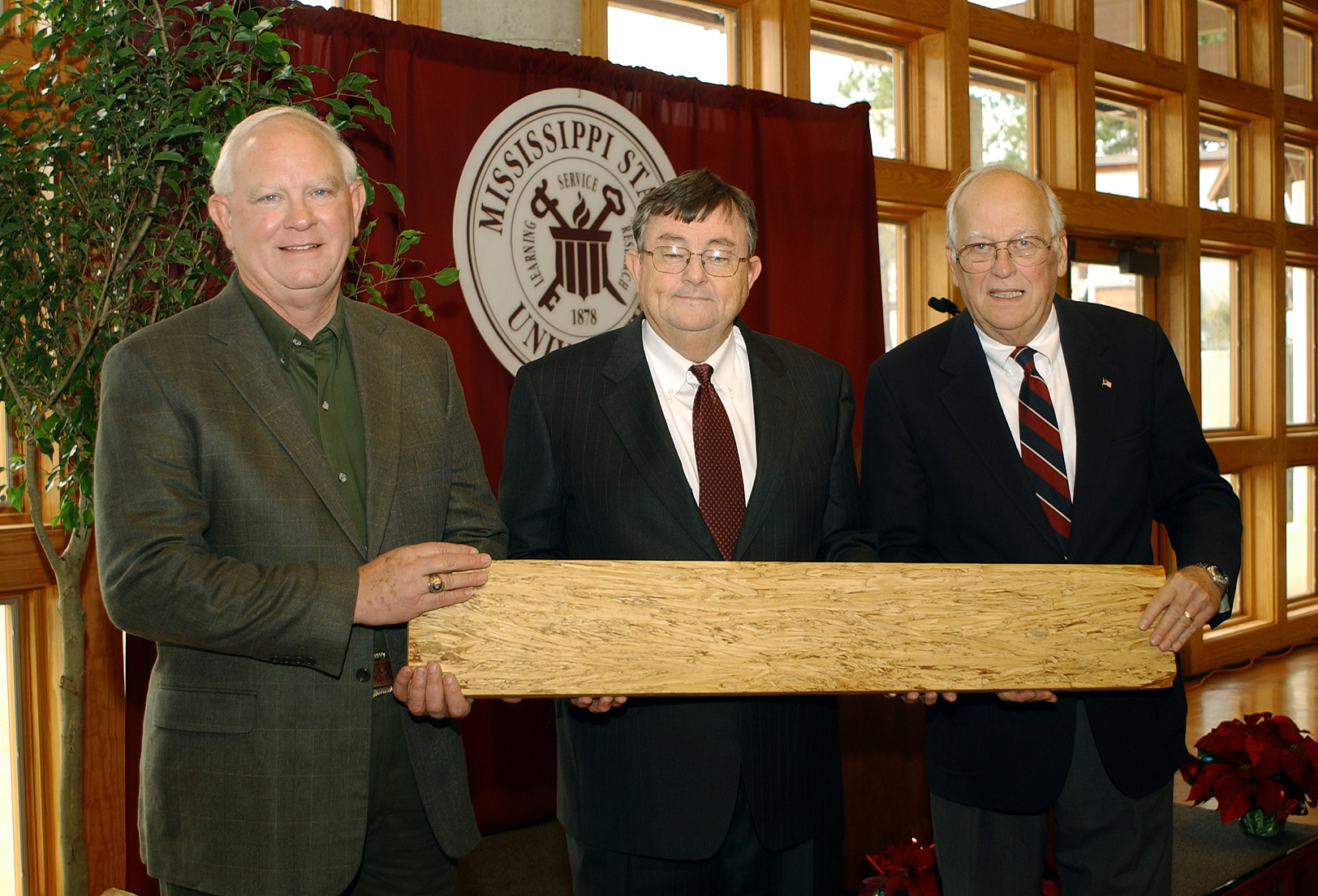 <br /><br />
During a Friday open house at Mississippi State, state Agriculture Commissioner Lester Spell (l), MSU President Charles Lee and TimTek Ltd. director Walter Jarck inspected a length of lumber produced at the TimTek demonstration plant on campus. The facility will utilize a new technology to convert strands from small-diameter pine trees into engineered lumber using adhesives, heat, and pressure 